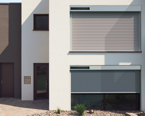 Rollladen mit Solarmodulen an der weißen Fassade eines Hauses